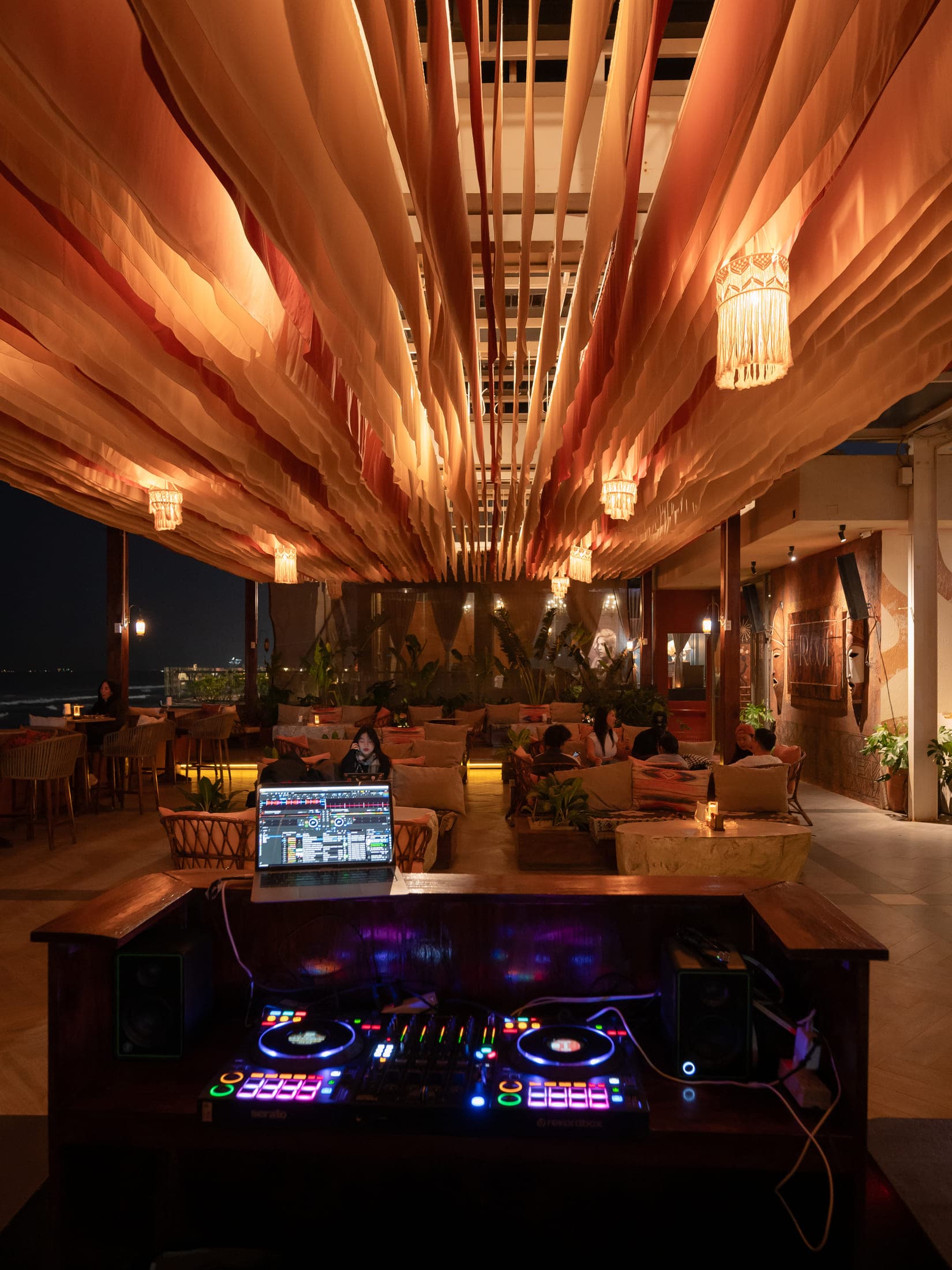 Quầy DJ tại The Roof, Đà Nẵng, phía sau là sân thượng và trần hình sóng về đêm